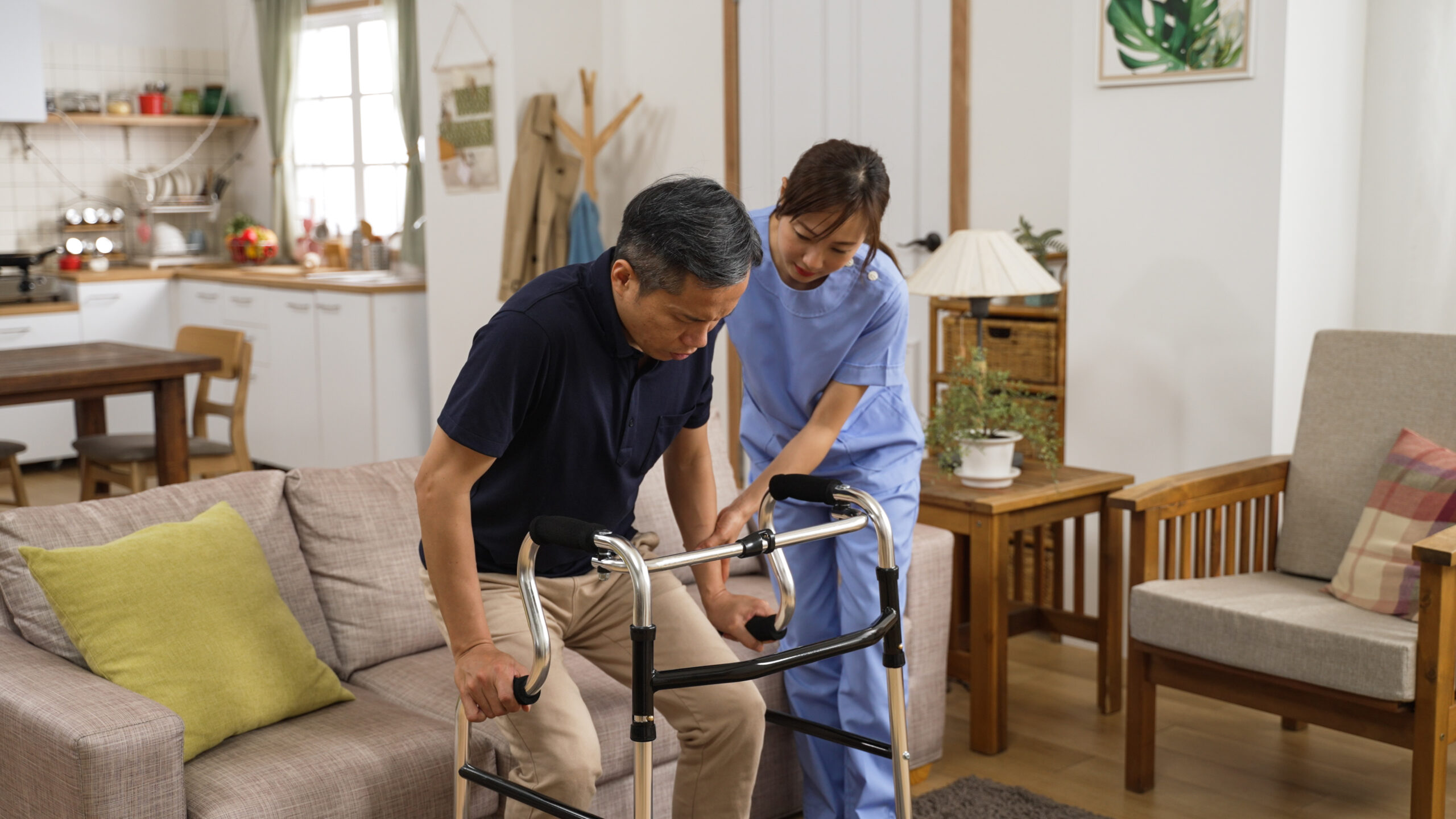 retired male assisted by nursing aide to use walker