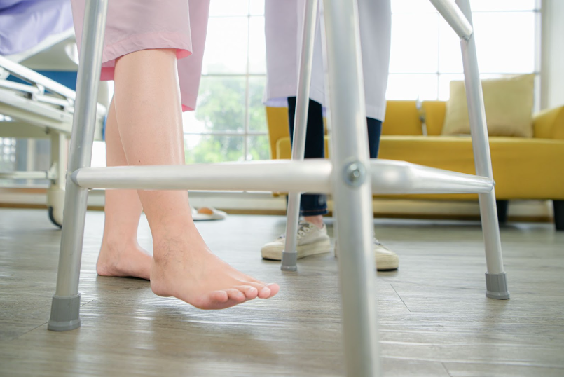 patient using a walking cane to move