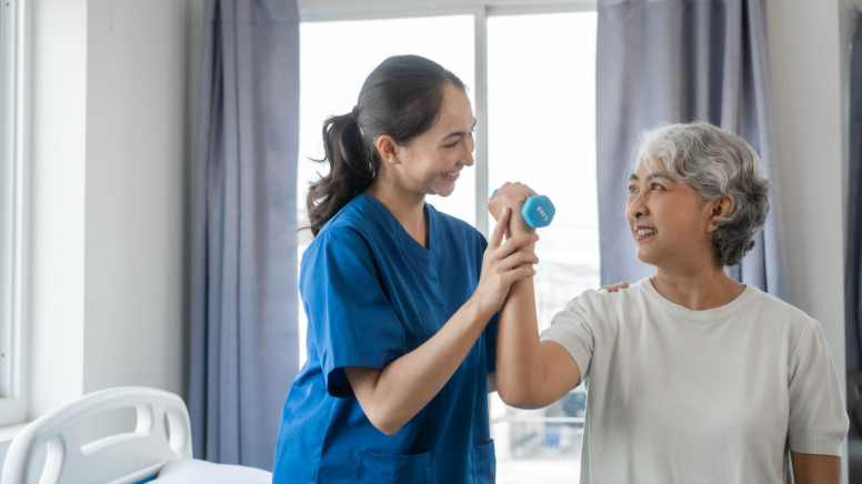 healthcare worker helping an elderly woman do exercises